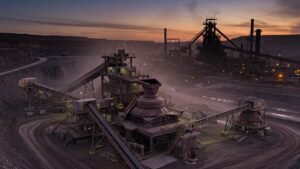 Crushing and screening plant lit at dusk inside an open pit